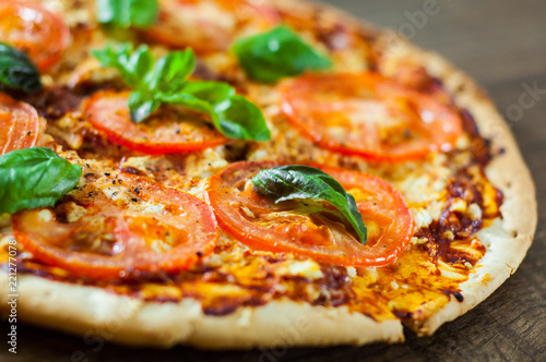 Pizza with Mozzarella cheese, Tomatoes, pepper, Spices and Fresh Basil. Italian pizza. Pizza Margherita or Margarita. on wooden background