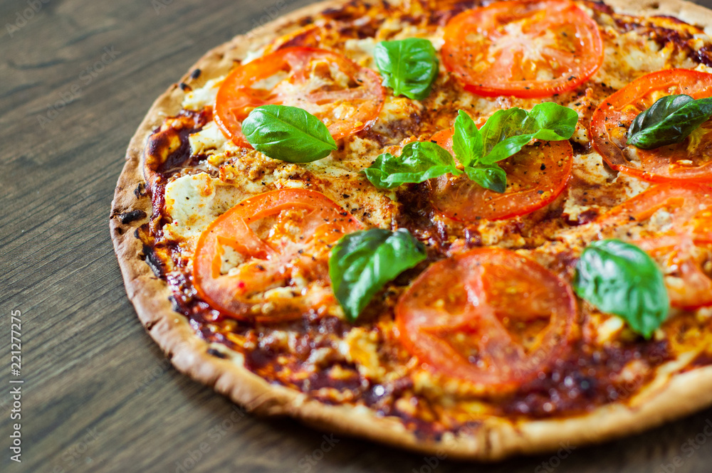 Pizza with Mozzarella cheese, Tomatoes, pepper, Spices and Fresh Basil. Italian pizza. Pizza Margherita or Margarita. on wooden background Pizza with Mozzarella cheese, Tomatoes, pepper, Spices and Fresh Basil. Italian pizza. Pizza Margherita or Margarita. on wooden background