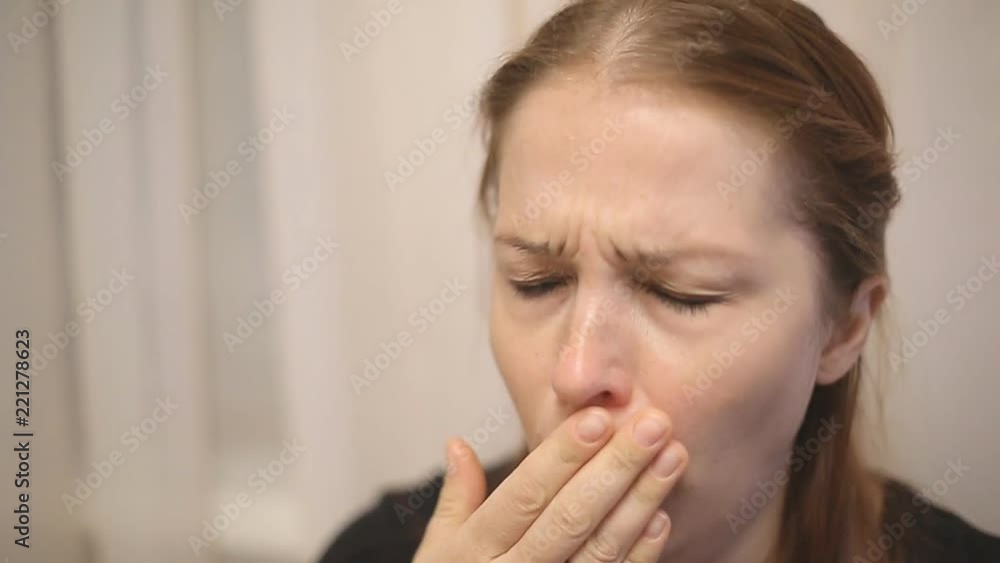a sick middle-aged woman sneezes and blows her nose in a handkerchief. a sick middle-aged woman sneezes and blows her nose in a handkerchief.