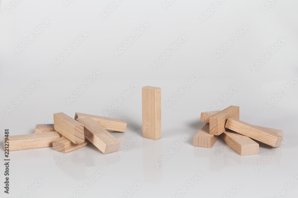 One wooden block standing and outstanding among the collapse of fall in line.. One wooden block standing and outstanding among the collapse of fall in line..