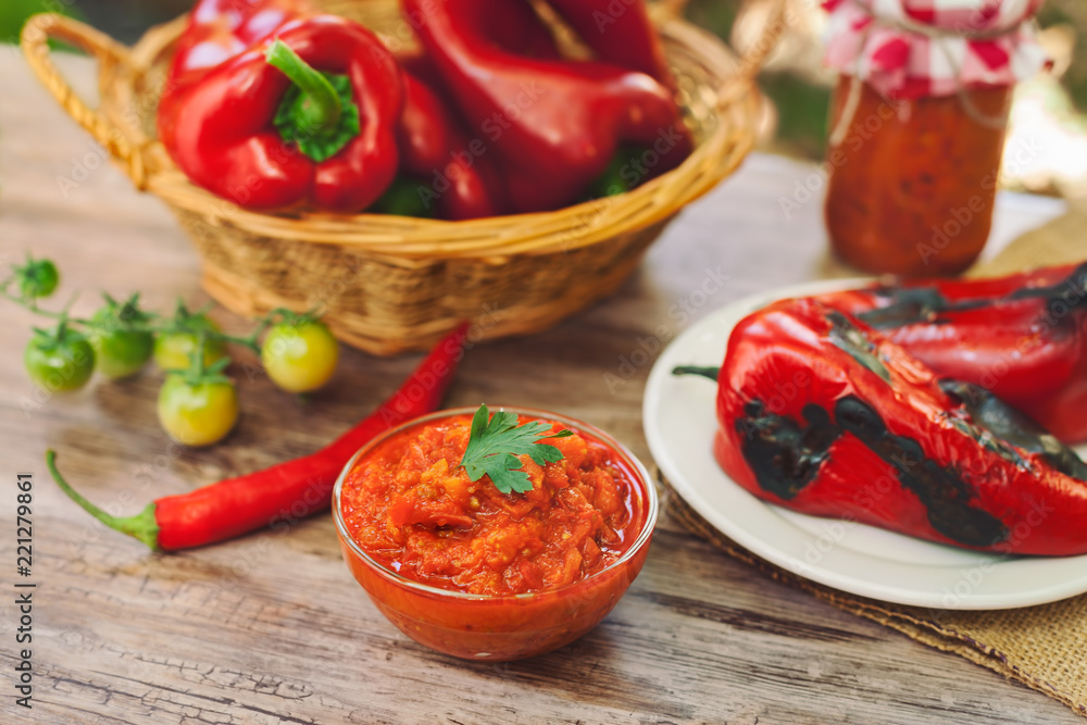Served Ajvar on table with roasted peppers Served Ajvar on table with roasted peppers