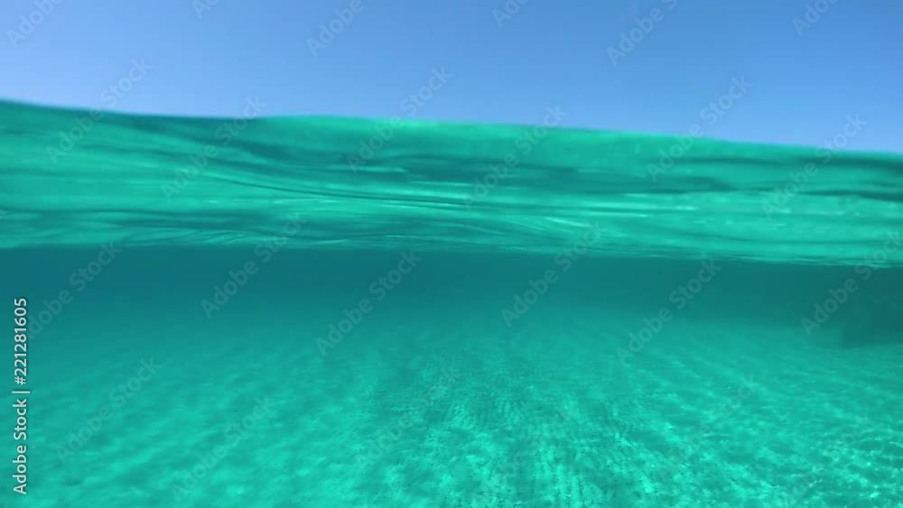 SLOW MOTION, HALF UNDERWATER: Spectacular shot of the distant island in the middle of the crystal clear ocean on a sunny day in summer. Awesome half underwater view of sandy ocean floor and Sardinia. SLOW MOTION, HALF UNDERWATER: Spectacular shot of the distant island in the middle of the crystal clear ocean on a sunny day in summer. Awesome half underwater view of sandy ocean floor and Sardinia.