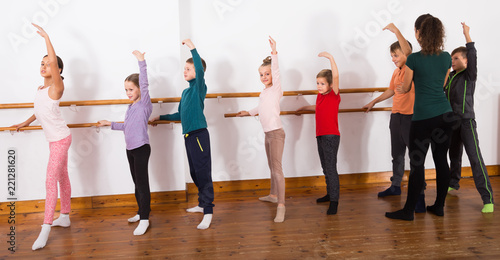 hard-working boys and girls rehearsing ballet dance in studio