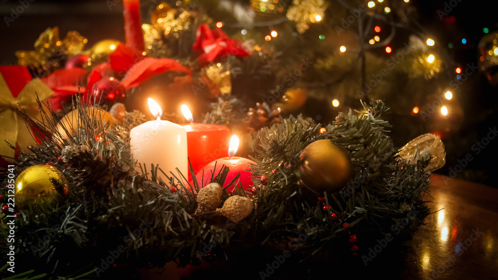 Toned image of burning candles and Christmas wreath on winter holidays