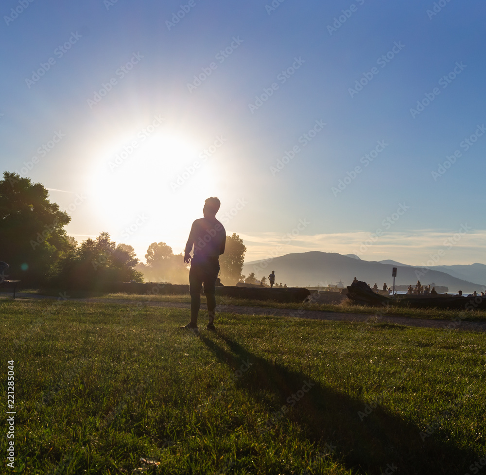 Person enjoying sunset, Kitsilano Beach Park, Vancouver, BC, Canada. Person enjoying sunset, Kitsilano Beach Park, Vancouver, BC, Canada.