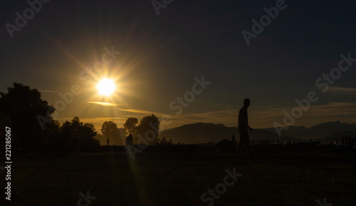 Person enjoying sunset, Kitsilano Beach Park, Vancouver, BC, Canada.