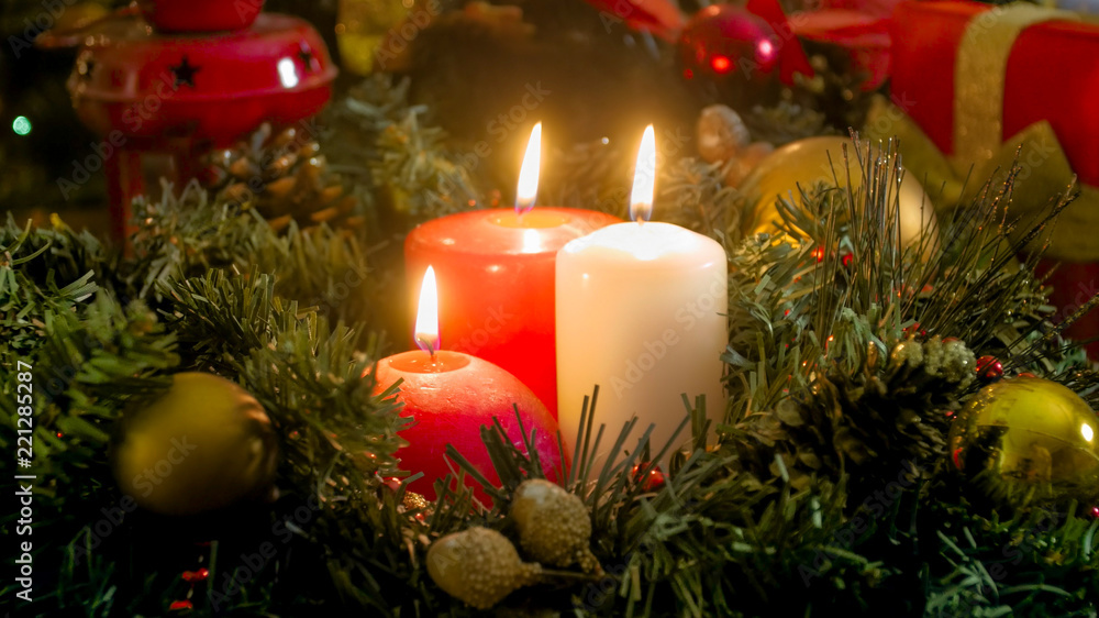 Closeup image of three burning candles on Christmas eve