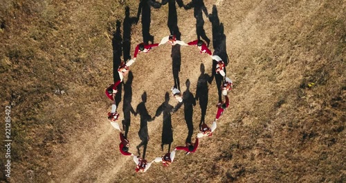 Aerial view: Top down view. A team of dancers circling in dance in the glade