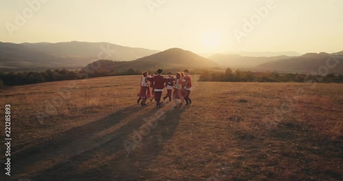 Aerial view: A team of dancers circling in dance in the glade