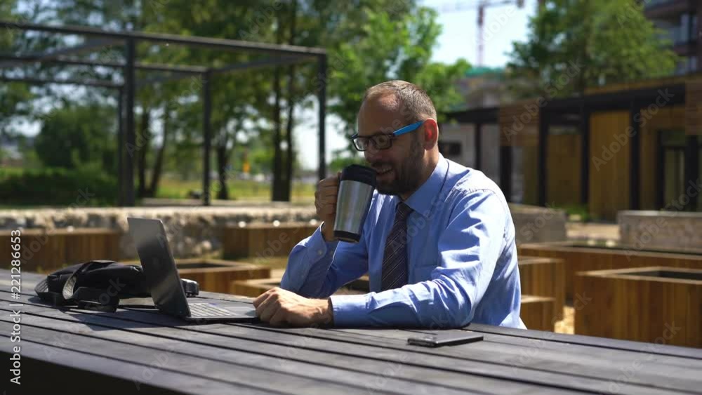 Young businessman watching movie on laptop at city park
Young businessman watching movie on laptop at city park