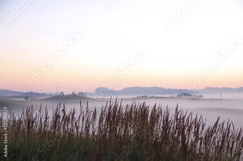 Colorful sunrise over rolling hills in the fog