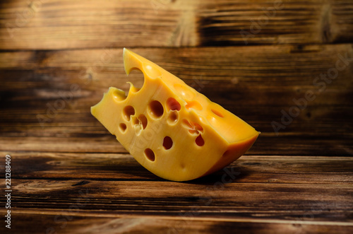 Piece of cheese on wooden table