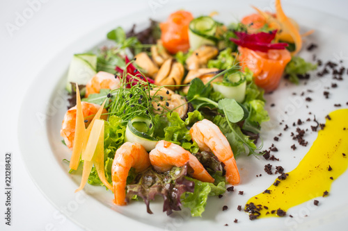 Seafood fresh salad with shrimps, mussels, salmon, green and cucumber