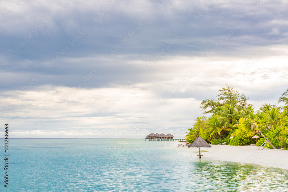 Fototapeta premium Beach umbrella on the beach atoll island Maldives. Calm tropical sunset