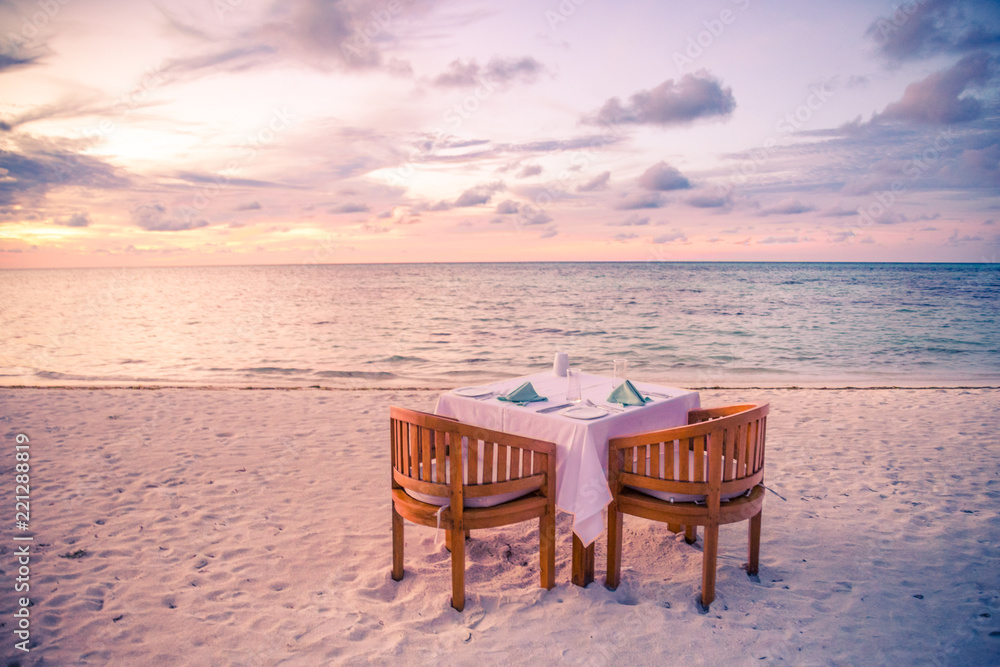 Romantic dinner on the beach with sunset. Honeymoon and couple getaway, beach dinner concept