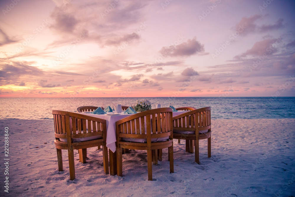 Romantic dinner on the beach with sunset. Honeymoon and couple getaway, beach dinner concept
