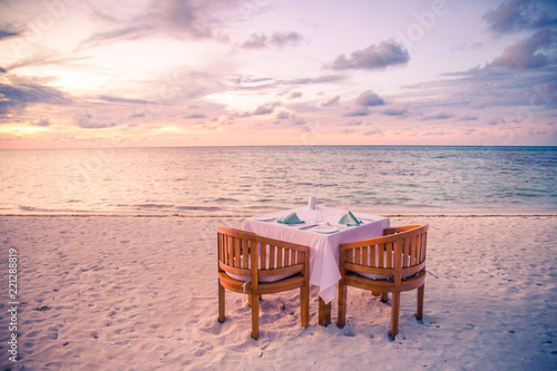 Romantic dinner on the beach with sunset. Honeymoon and couple getaway, beach dinner concept photo