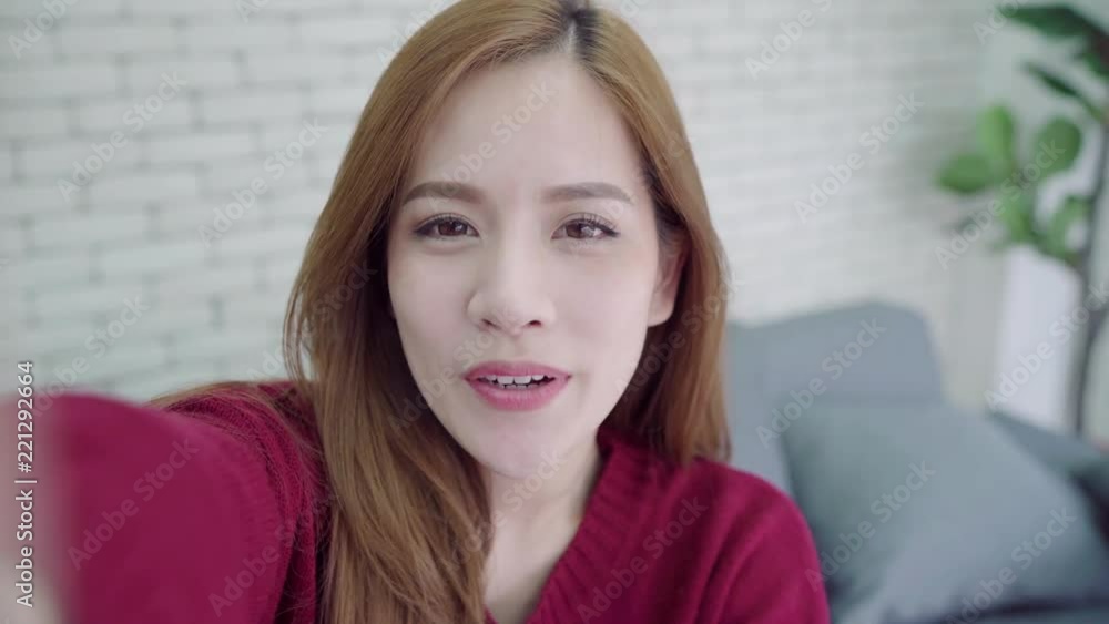 Happy young Asian woman taking selfie and video call with smartphone at home. Happy young Asian woman taking selfie and video call with smartphone at home.