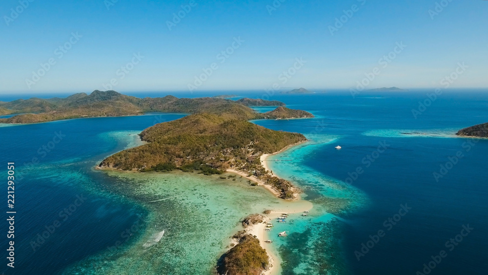Aerial view of tropical beach on the Bulog Dos Island, Philippines. Beautiful tropical island with sand beach, palm trees. Tropical landscape: beach with palm trees. Seascape: Ocean, sky, sea. Travel
