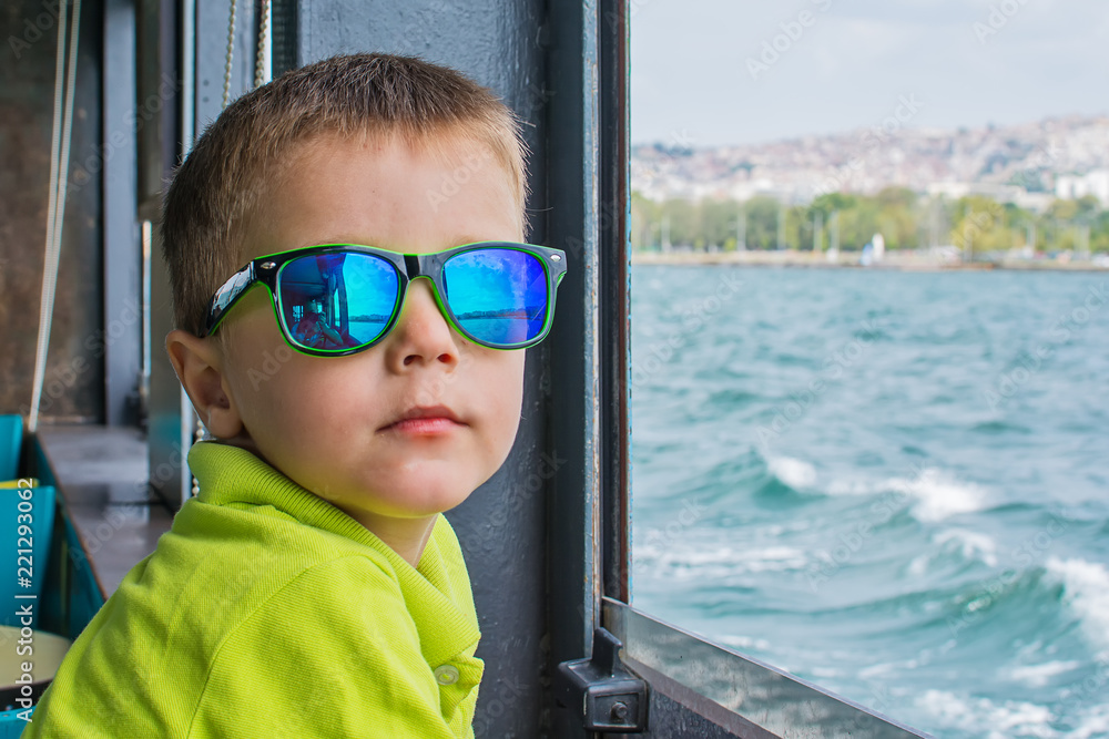 The boy on the boat looks at the coast of Thessaloniki The boy on the boat looks at the coast of Thessaloniki