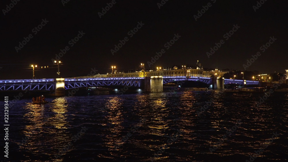 Bridge over the river, illuminating the water with light from lampposts. City night scene with illuminated drawbridge over river. Saint Petersburg,Russia.