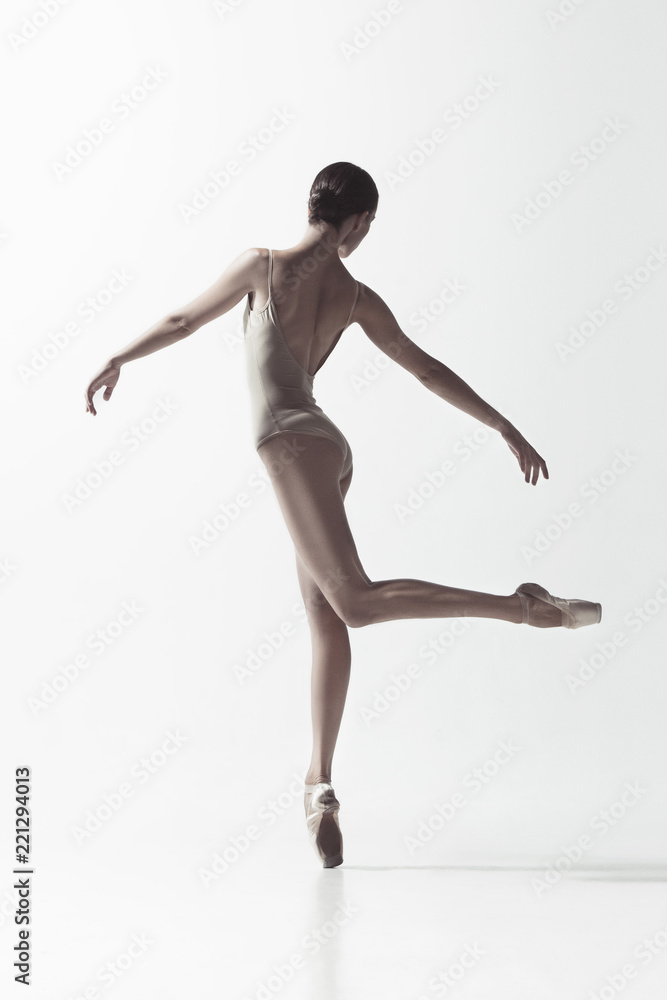 Obraz premium Young graceful female ballet dancer or classic ballerina dancing isolated on white studio. Caucasian model on pointe shoes