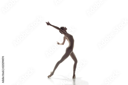 Young graceful female ballet dancer or classic ballerina dancing isolated on white studio. Caucasian model on pointe shoes