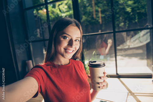 Beautiful young woman doing selfie on the front camera of her sm photo