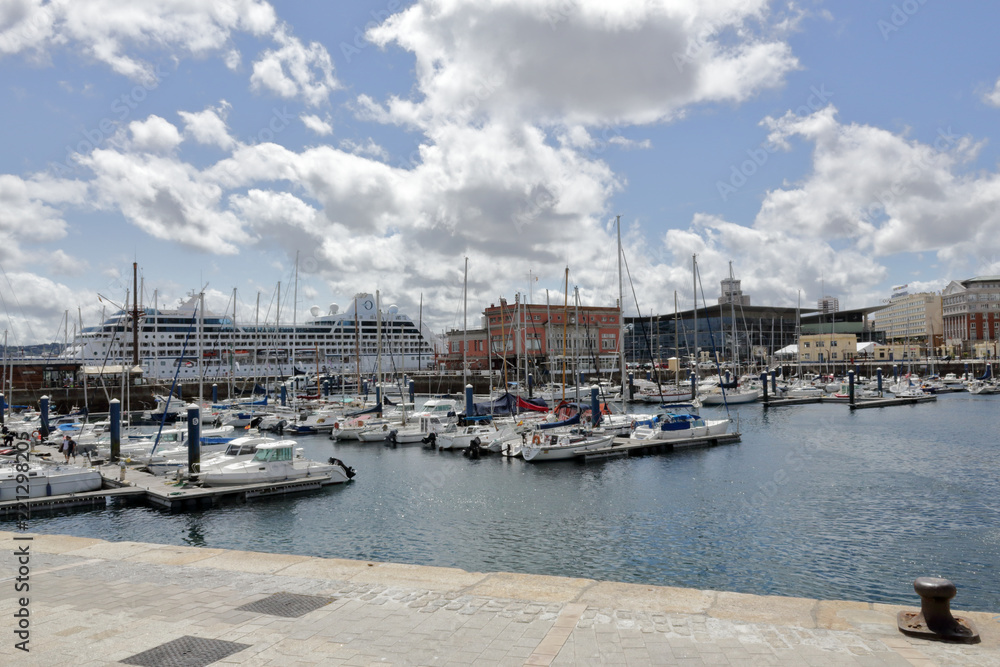 The piers of La Coruña marina sea port with many sailing boats and a blue sky with some clouds