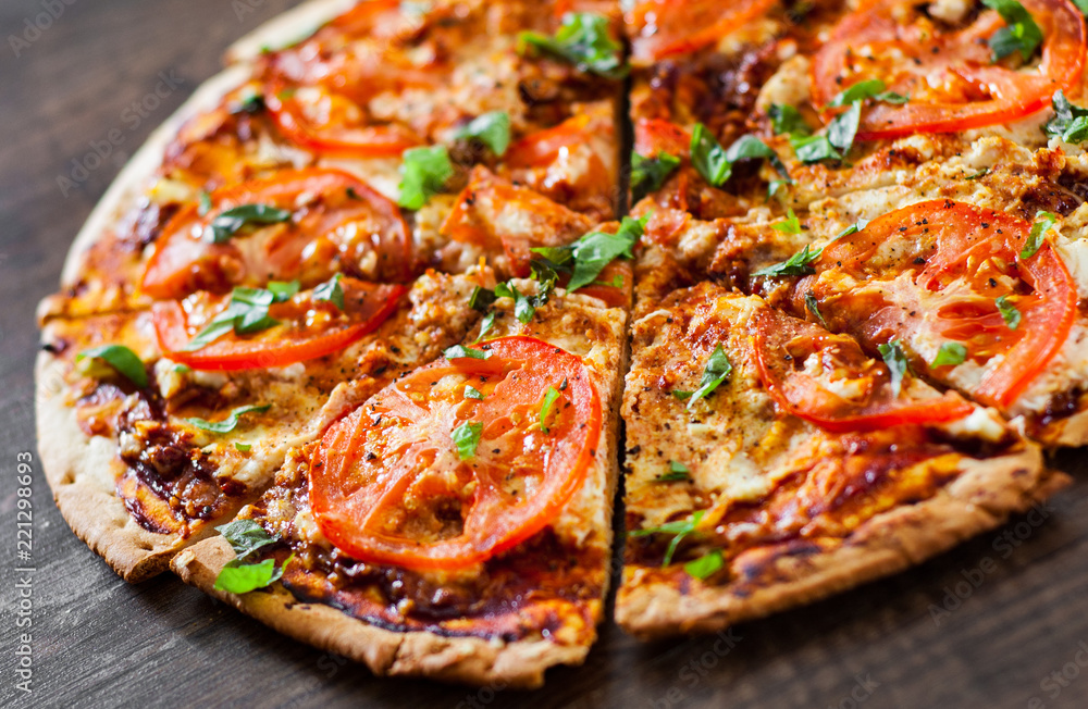 Pizza with Mozzarella cheese, Tomatoes, pepper, Spices and Fresh Basil. Italian pizza. Pizza Margherita or Margarita. on wooden background Pizza with Mozzarella cheese, Tomatoes, pepper, Spices and Fresh Basil. Italian pizza. Pizza Margherita or Margarita. on wooden background