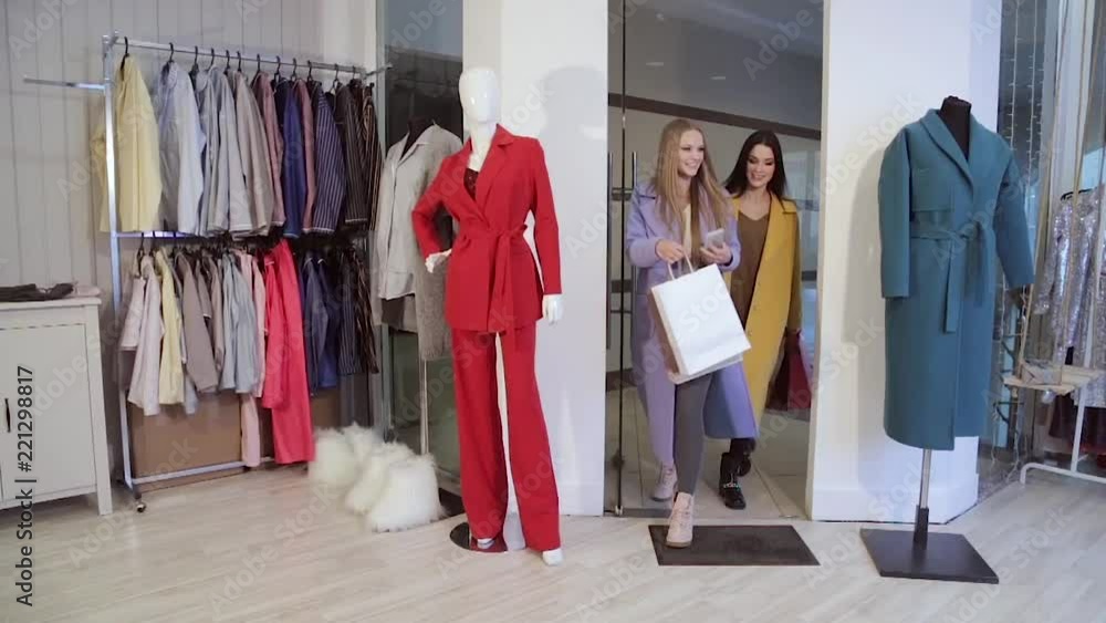 Great day for shopping. Two beautiful women with shopping bags walking at the clothing store. Great day for shopping. Two beautiful women with shopping bags walking at the clothing store.