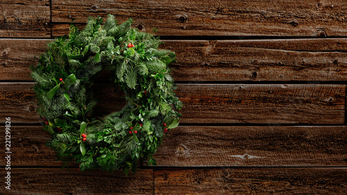 Green natural advent wreath of green fir twigs and mistletoes hanging on a vintage wooden wall, studio shot with copy space, no people