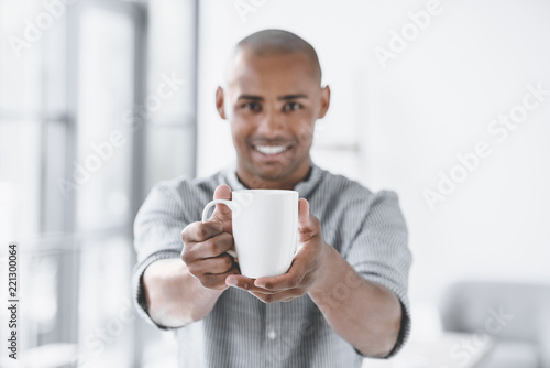 selective focus of african american businessman holding cup of coffee in hands