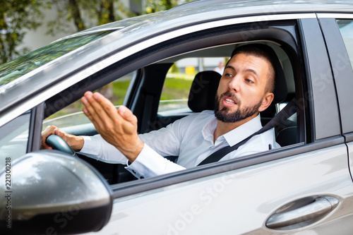Upset businessman driving a car