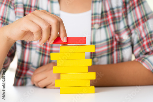 Concept of building success foundation. Women hand put colorful wooden blocks in the shape of a staircase