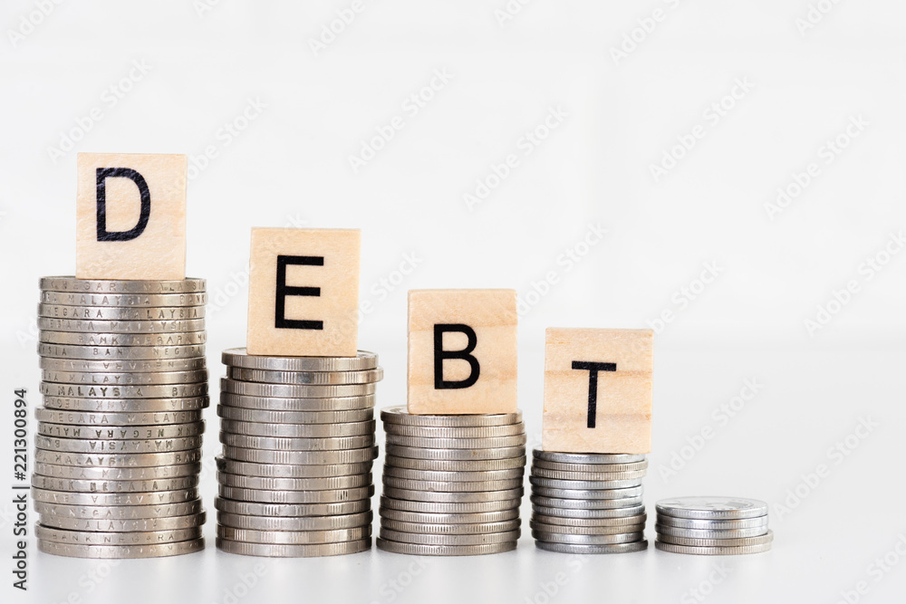 DEBT text on stacks of coins. Financial and saving money concept. DEBT text on stacks of coins. Financial and saving money concept.