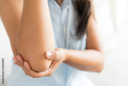 Close up woman having pain in injured elbow. Health care and arm pain concept. © Siam