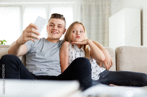 Siblings taking selife at home photo