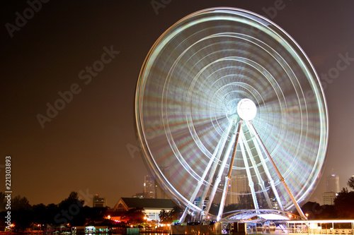 A great long exposure shot of a spinning illuminated Ferris wheel at night in Malaysia.