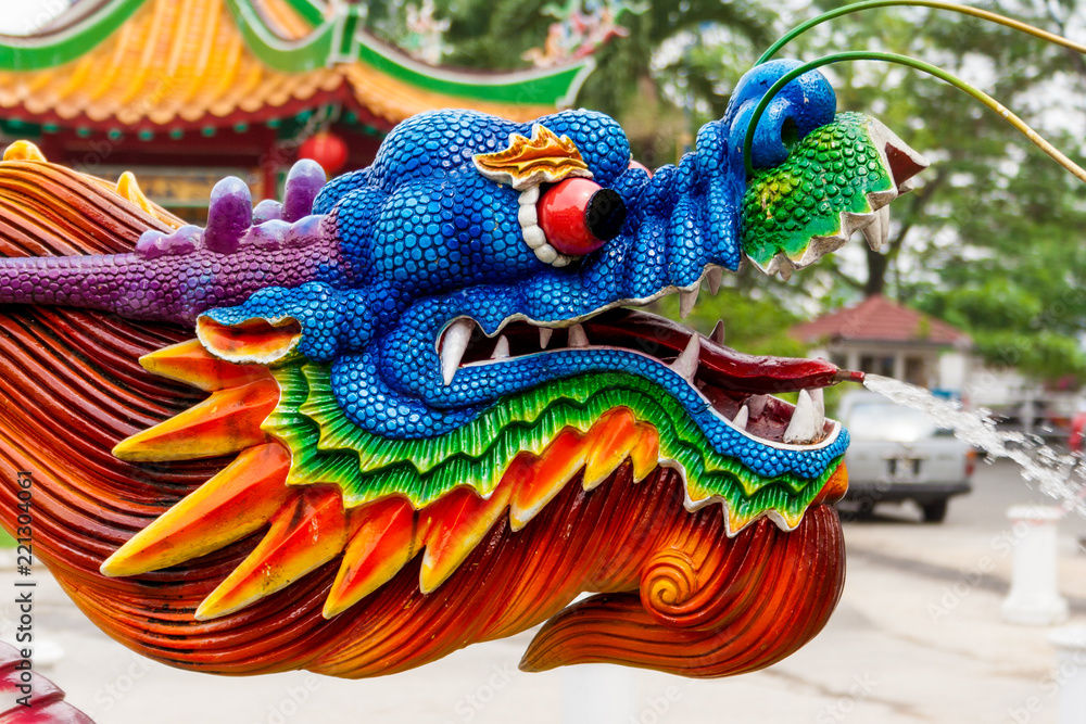 A nice close-up of a colourful water spraying dragon head at a Chinese temple. The water jet comes out of its tongue.
