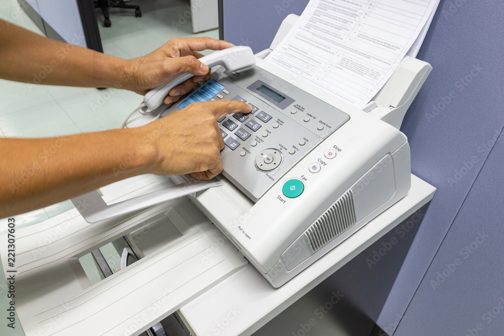 hand man are using a fax machine in the office. Business concept hand man are using a fax machine in the office. Business concept