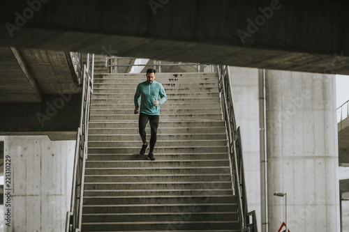 Young man running down the stairs in urban enviroment