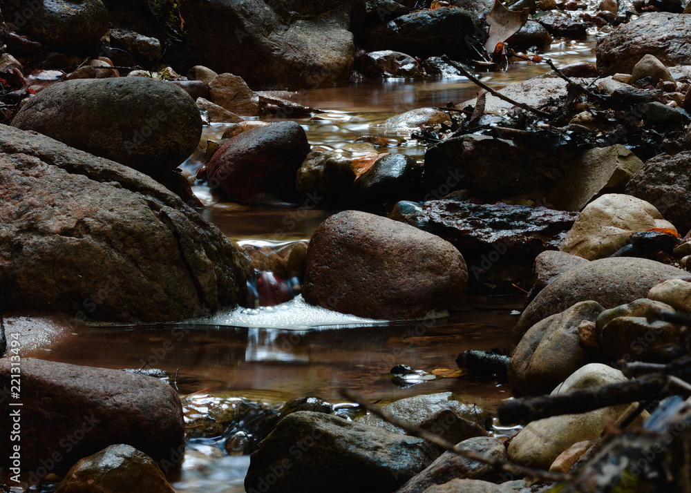 Small stream flowing through rocks with long exposure Small stream flowing through rocks with long exposure