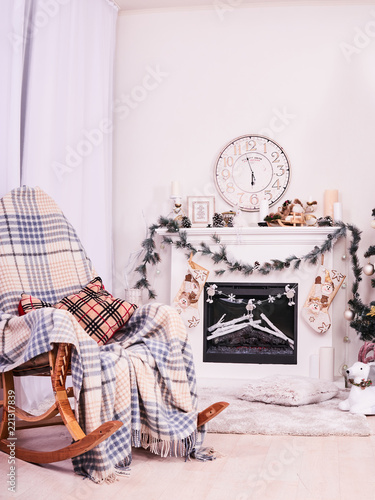 Xmas Fireplace with armchair, clocks and pillows. Christmas stocking over fireplace, New Year's card scenery. Snowman and stars. New Year concept. photo