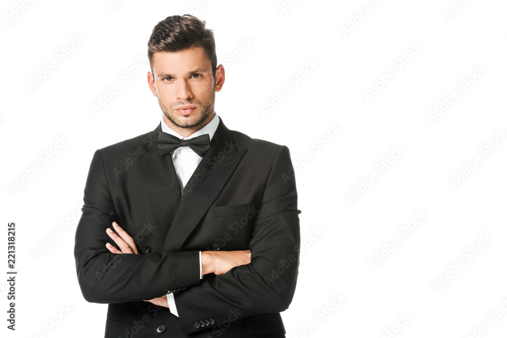 handsome young man in black suit with bowtie with crossed arms isolated on white handsome young man in black suit with bowtie with crossed arms isolated on white