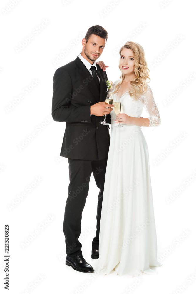happy young bride and groom with glasses of champagne looking at camera isolated on white happy young bride and groom with glasses of champagne looking at camera isolated on white