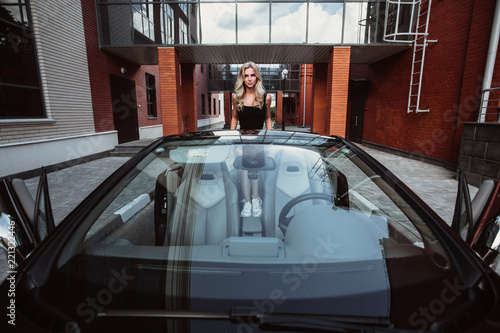 beautiful girl in a beautiful car cabriolet on the background of a beautiful building
