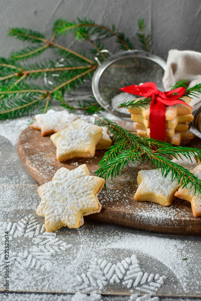 Preparation for new year 2019: pastry biscuits in the form of stars with powdered sugar, decorated red bow and branches of a Christmas tree. the table with powdered sugar in the form of a snowflake Preparation for new year 2019: pastry biscuits in the form of stars with powdered sugar, decorated red bow and branches of a Christmas tree. the table with powdered sugar in the form of a snowflake