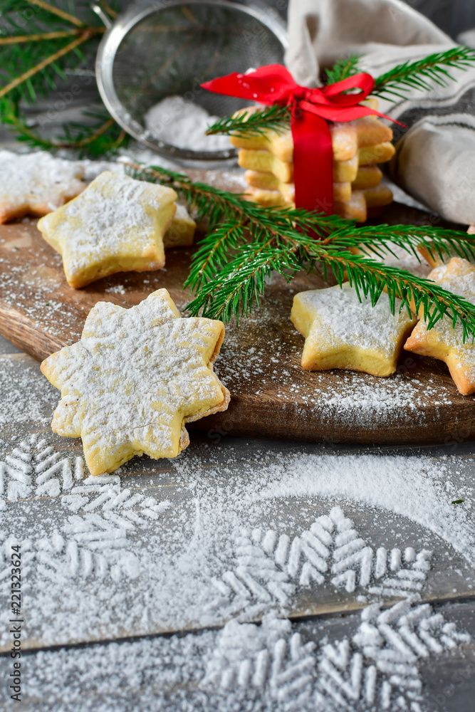 Preparation for new year 2019: pastry biscuits in the form of stars with powdered sugar, decorated red bow and branches of a Christmas tree. the table with powdered sugar in the form of a snowflake Preparation for new year 2019: pastry biscuits in the form of stars with powdered sugar, decorated red bow and branches of a Christmas tree. the table with powdered sugar in the form of a snowflake