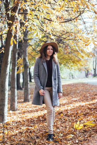 Autumn woman in autumn park in cozy sweater,coat and hat. Warm sunny weather. Fall concept © tatyanasuyarova